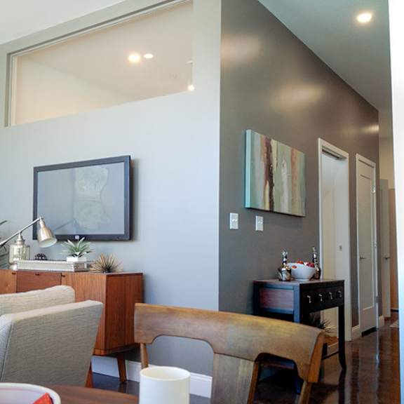 a living room with a grey couch and a wooden cabinet.